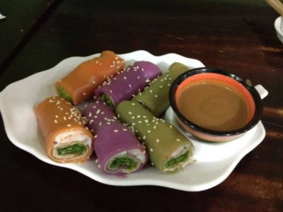 Colorful rice rolls with dipping sauce, a Saigon street snack