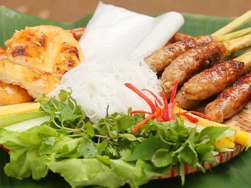 Nem Lui: Grilled pork skewers served with rice paper and fresh herbs.