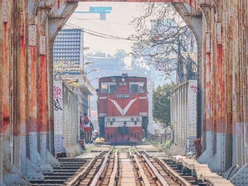 Train passing through an archway near Long Bien Bridge in Hanoi