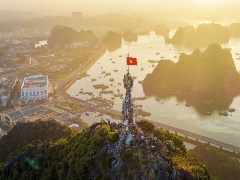 The red flag with a yellow star flutters atop Bai Tho Mountain