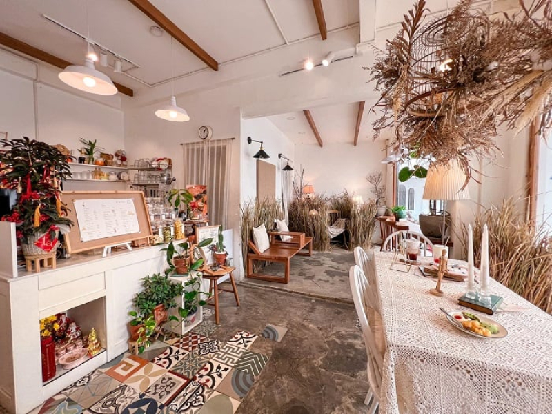 The cafe's design is inspired by nature, with lots of greenery and wooden furnishings (Source: Collected)