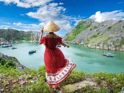Amazing 2 Week Vietnam Itinerary: Hanoi to Hoi An Traveler in a conical hat overlooking the karst islands of Cat Ba