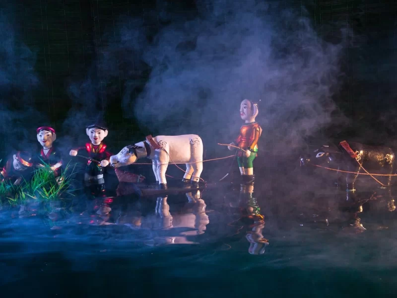 Water puppets performing on stage at a Hoi An water puppet show