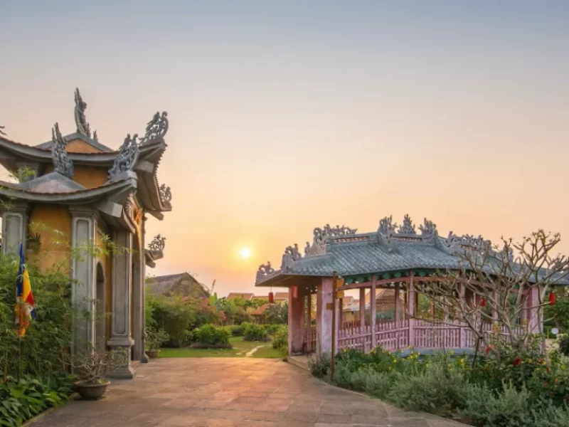 Pagoda-style gate and covered bridge pavilion at sunset in the Japanese Village area of Hoi An Impression Theme Park