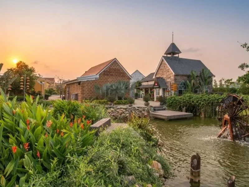 Sunset view of the European-style stone village and water wheel at Hoi An Impression Theme Park