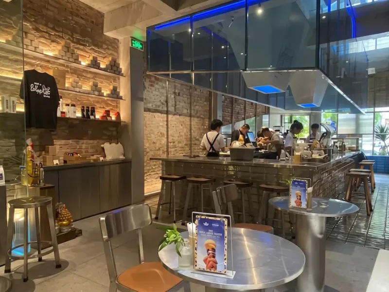 Modern Interior of The Running Bean Hanoi - Vietnam Discovery Tours Spacious industrial-style interior with exposed brick walls and open coffee counter at The Running Bean near St. Joseph's Cathedral Hanoi