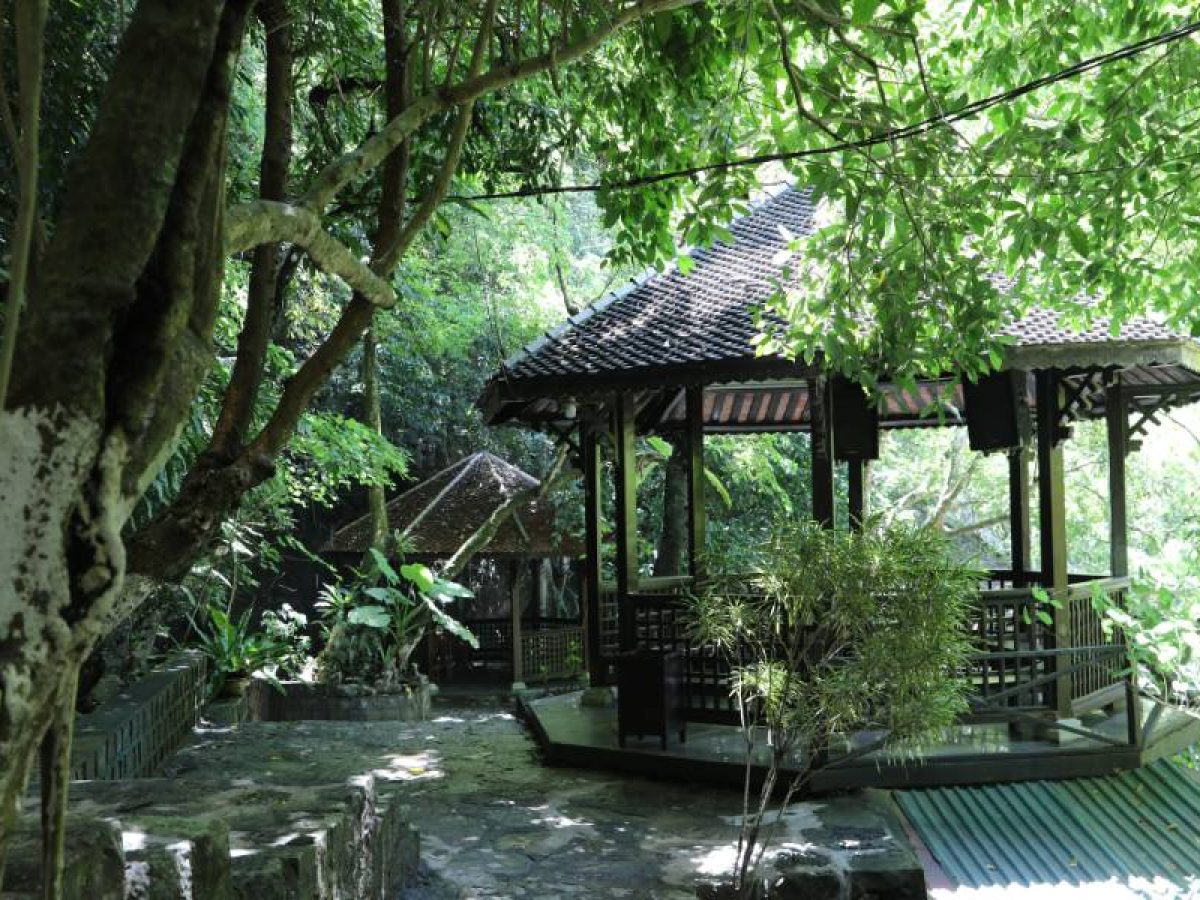 Trang An Boat Tour 2026: Routes, Tickets & Local Tips Wooden pavilion shaded by trees at a temple stop in Trang An