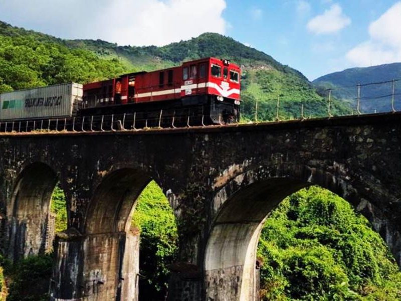 Hue to Da Nang Heritage Train A Must-Try Vietnam Journey Red heritage train crossing a stone arch bridge between Hue and Da Nang