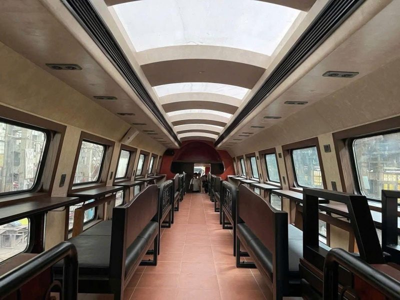 Glass-roof train car, window seats, perfect for scenic views.