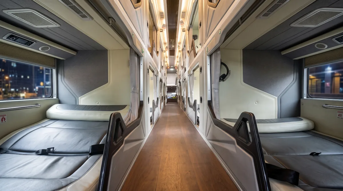Hanoi to Sapa VIP Sleeper Bus Lower Double Cabin | Vietnam Discovery Tours Spacious lower double cabin interior on VIP sleeper bus from Hanoi to Sapa with leather mattress and panoramic window