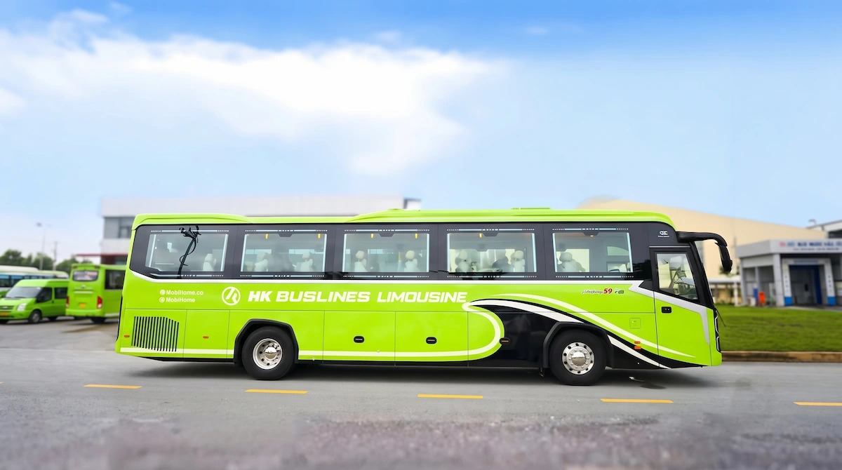 Modern green VIP limousine bus by HK Buslines for Hanoi to Sapa route parked outdoors on sunny day