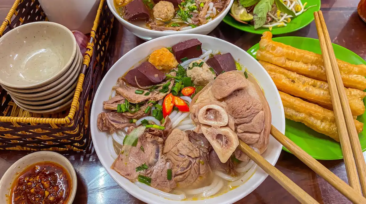 Authentic Hanoi Bun Cha Street Food - Vietnam Discovery Tours Authentic Bun Bo Hue spicy beef and pork noodle soup with herbs and quai recommended by Vietnam Discovery Tours