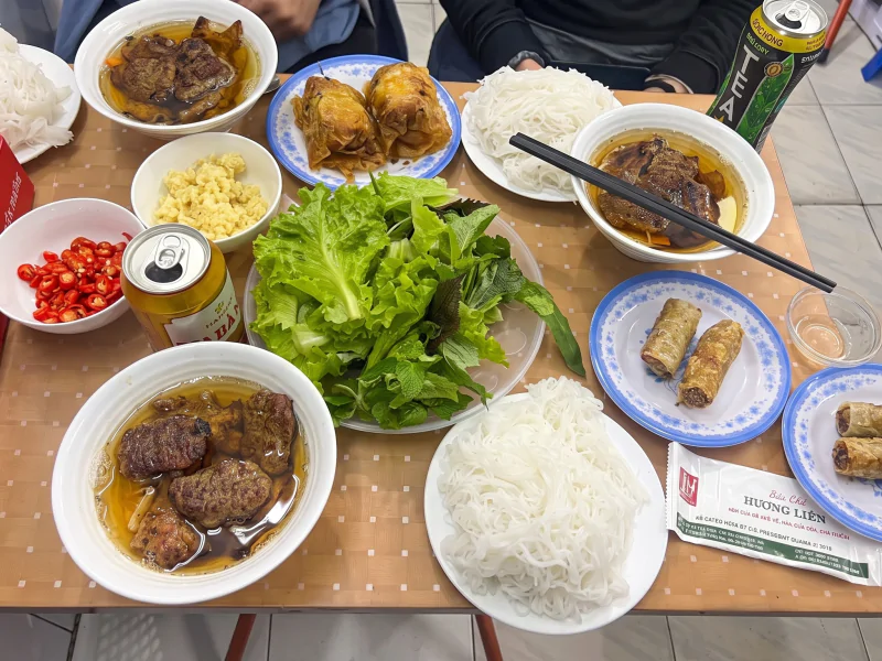 Bun Cha Huong Lien Dining Table Hanoi - Vietnam Discovery Tours Authentic Bun Cha Huong Lien meal set with grilled pork, seafood spring rolls, and noodles - Vietnam Discovery Tours